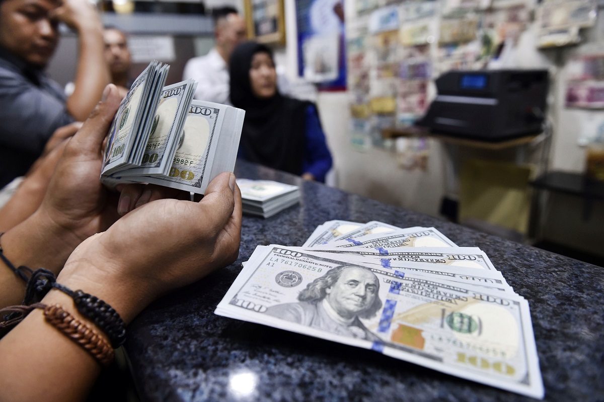seorang konsumen melakukan penukaran mata uang dolar as di jasa penukaran uang asing valuta artha mas itc kuningan, jakarta, rabu (28/2).